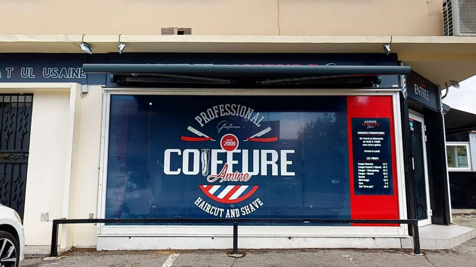 Devanture rouge, blanche et bleu marine d'Amine Coiffure